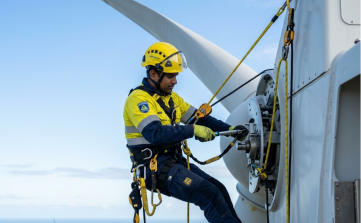 Wind energy rope access technician performing maintenance and repairs on a wind turbine rotor hub